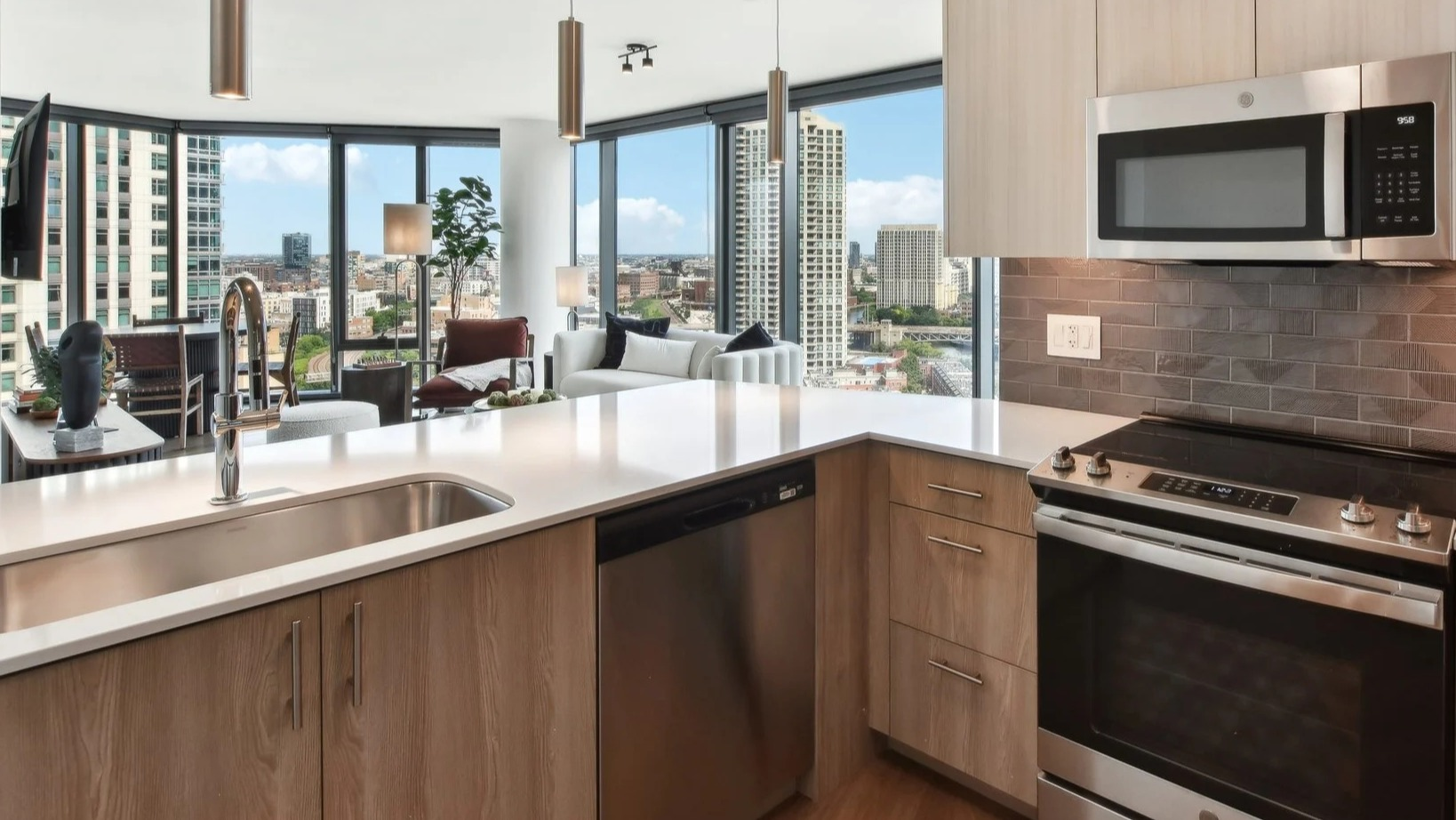 Bright apartment kitchen with light cabinetry, stainless steel appliances, and an open view into the living area at Cassidy on Canal in Chicago