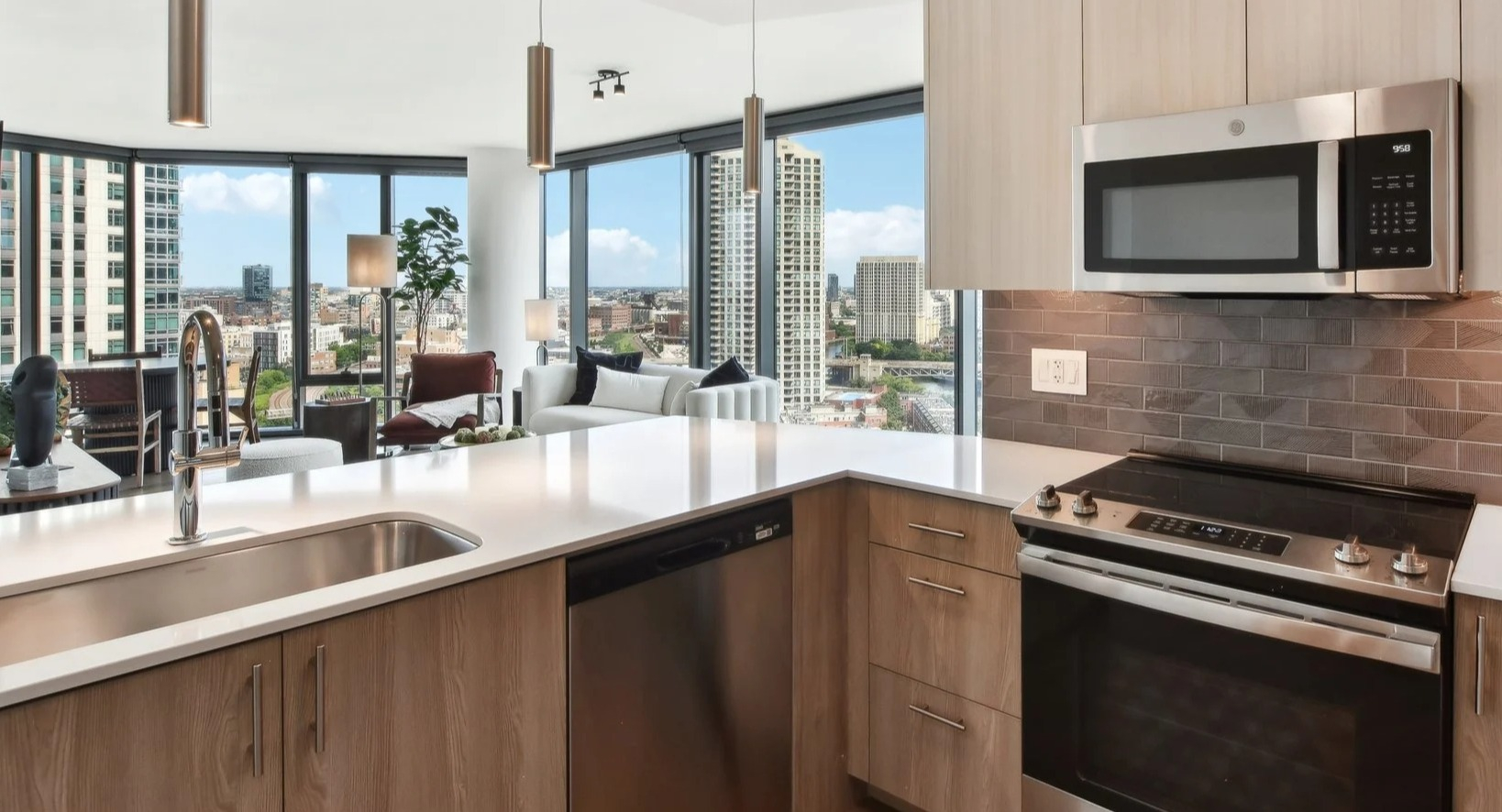 Bright apartment kitchen with light cabinetry, stainless steel appliances, and an open view into the living area at Cassidy on Canal in Chicago