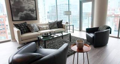Bright living room at Catalyst apartments in Chicago with floor-to-ceiling windows, offering ample natural light and city views