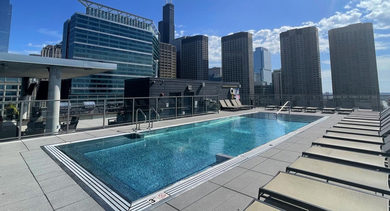 Sparkling rooftop swimming pool at Catalyst apartments in Chicago, offering panoramic cityscape views on a sunny day
