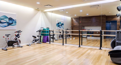 Dedicated yoga and spin studio at Catalyst apartments in Chicago, featuring exercise bikes, ballet barre, and mirrors