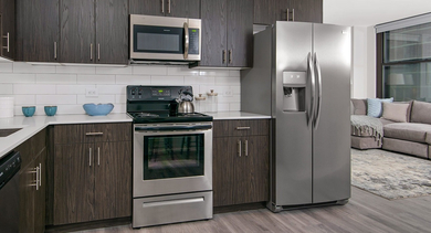 Contemporary kitchen layout with white subway tile backsplash, stainless steel appliances, and abundant storage at Century Tower Apartments Chicago