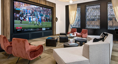 Spacious resident lounge with a large screen for movies or sports, comfortable seating, and stylish decor at Century Tower Apartments Chicago