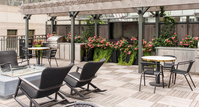 Rooftop deck with outdoor grills, dining tables, and comfortable seating for residents at Century Tower Apartments Chicago