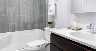 Updated bathroom with contemporary grey tile shower, modern vanity, and sleek fixtures at Century Tower Apartments Chicago