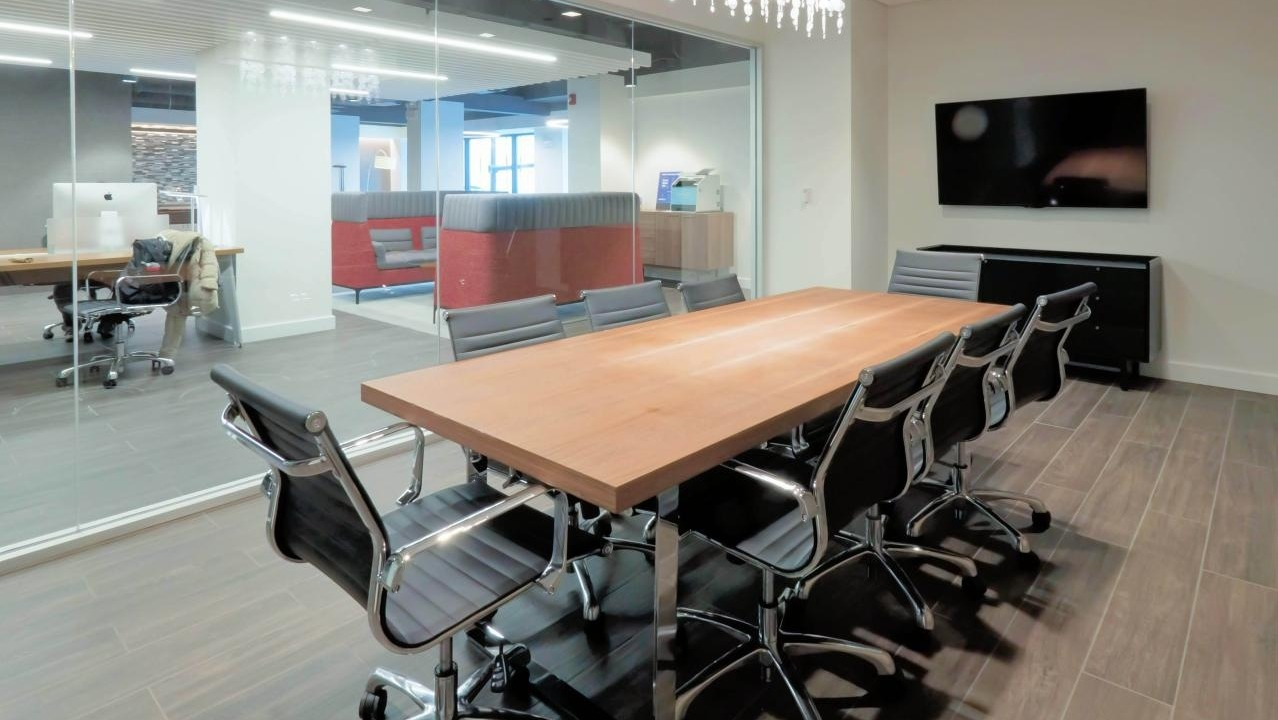 Professional conference room at Chestnut Place apartments in Chicago with a large table, office chairs, and glass walls