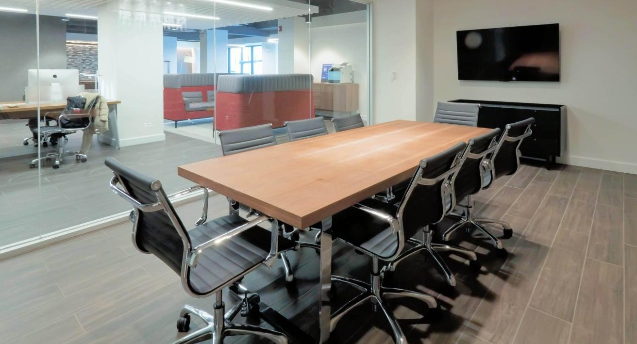 Professional conference room at Chestnut Place apartments in Chicago with a large table, office chairs, and glass walls