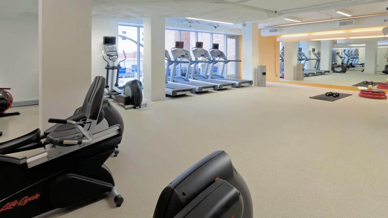 Modern fitness center at Chestnut Place apartments in Chicago featuring various cardio machines and fitness equipment