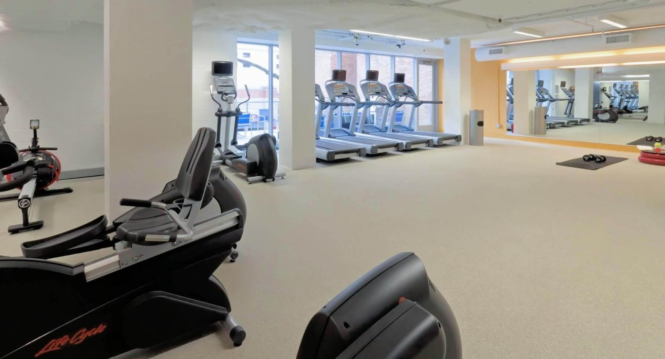 Modern fitness center at Chestnut Place apartments in Chicago featuring various cardio machines and fitness equipment