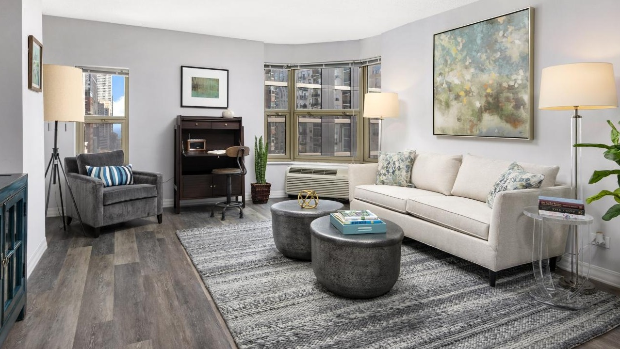 Spacious living room at Chestnut Place apartments in Chicago, featuring a designated home office nook and city views