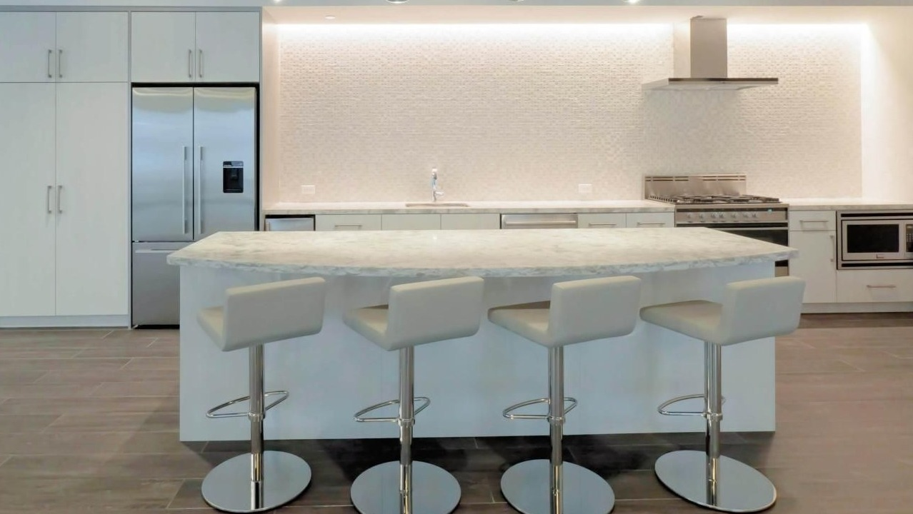 Modern kitchen at Chestnut Place apartments in Chicago with a large island, white cabinets, and stainless steel appliances