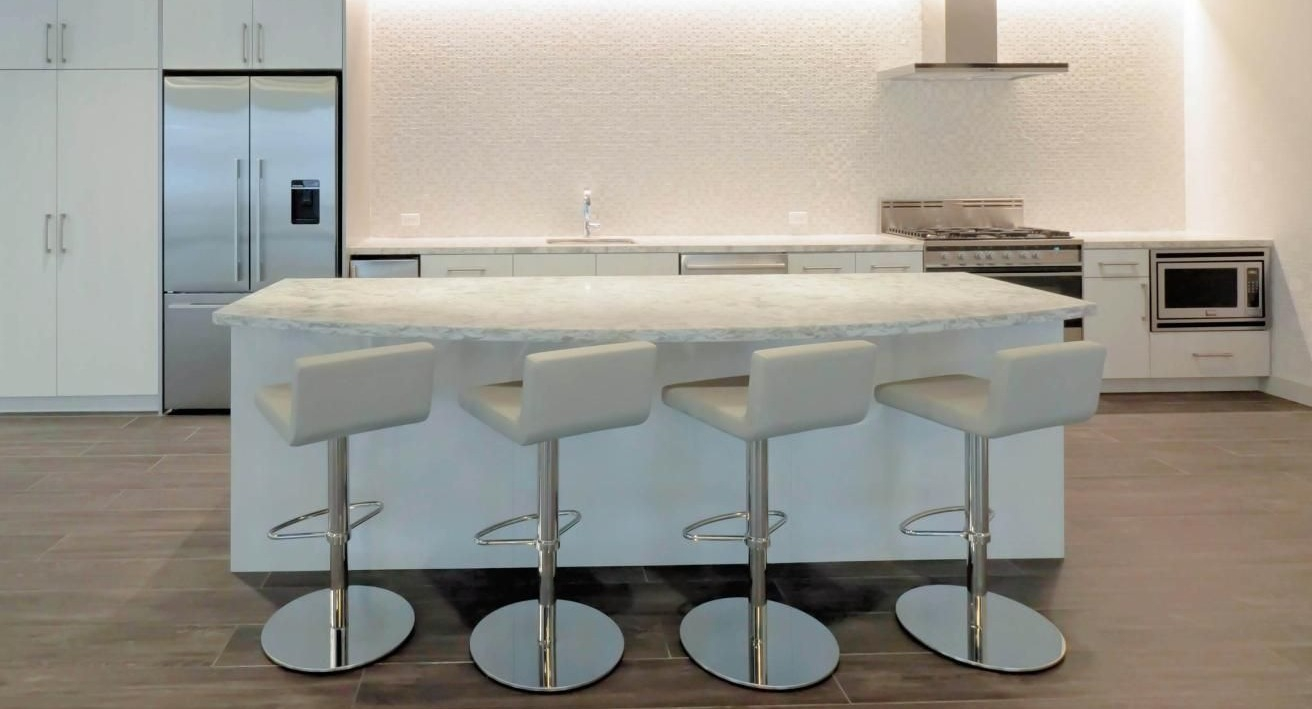 Modern kitchen at Chestnut Place apartments in Chicago with a large island, white cabinets, and stainless steel appliances