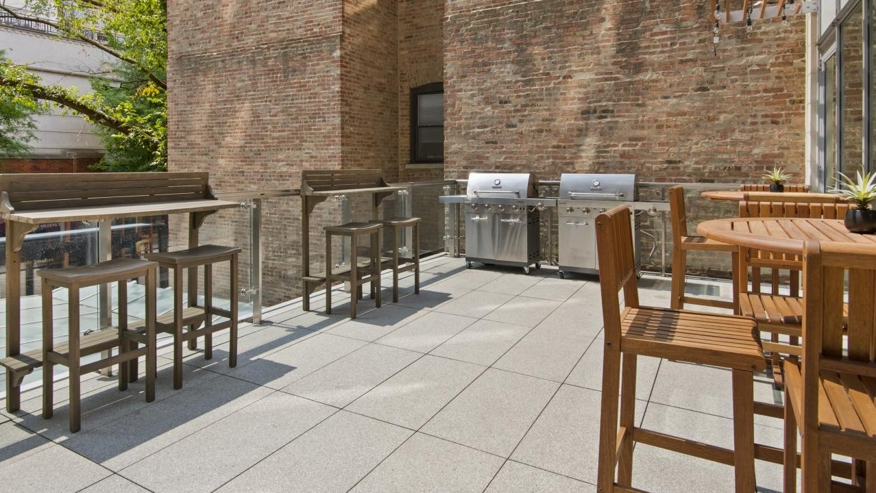 Outdoor grilling patio at Chestnut Place apartments in Chicago, equipped with BBQ grills and bar-height seating