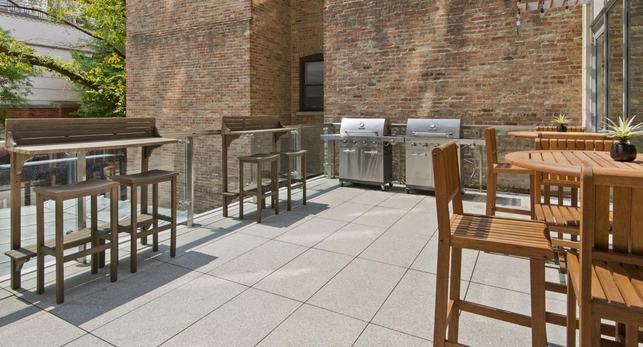 Outdoor grilling patio at Chestnut Place apartments in Chicago, equipped with BBQ grills and bar-height seating