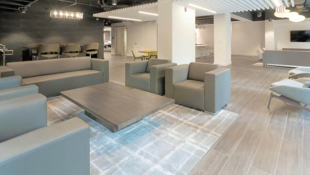 Inviting resident lounge at Chestnut Place apartments in Chicago with comfortable sofas, chairs, and modern lighting