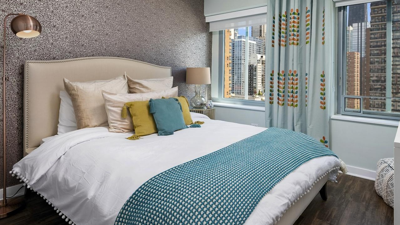 A chic bedroom at Chestnut Towers, with a stylish bed, decorative accents, and large windows overlooking the city