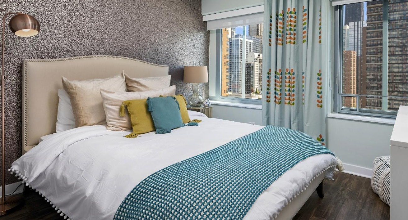 A chic bedroom at Chestnut Towers, with a stylish bed, decorative accents, and large windows overlooking the city