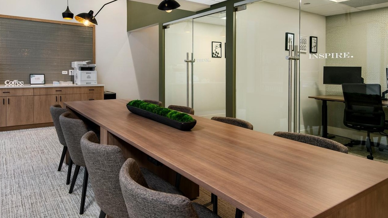 A professional conference room and private workspaces at Chestnut Towers, complete with a long table and coffee station