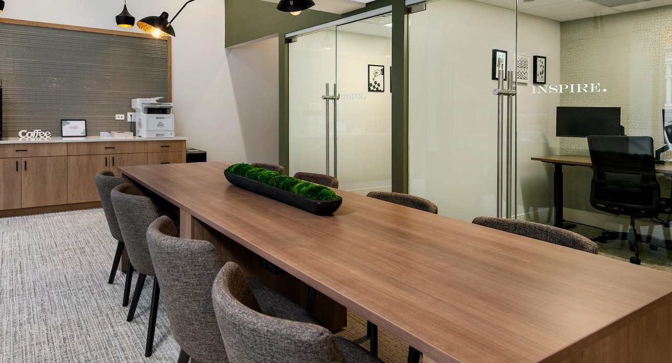 A professional conference room and private workspaces at Chestnut Towers, complete with a long table and coffee station