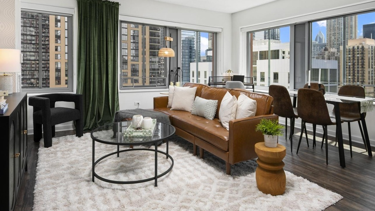 A welcoming living room at Chestnut Towers, offering a comfortable sofa, dining area, and expansive city views