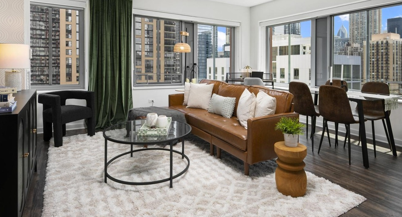 A welcoming living room at Chestnut Towers, offering a comfortable sofa, dining area, and expansive city views