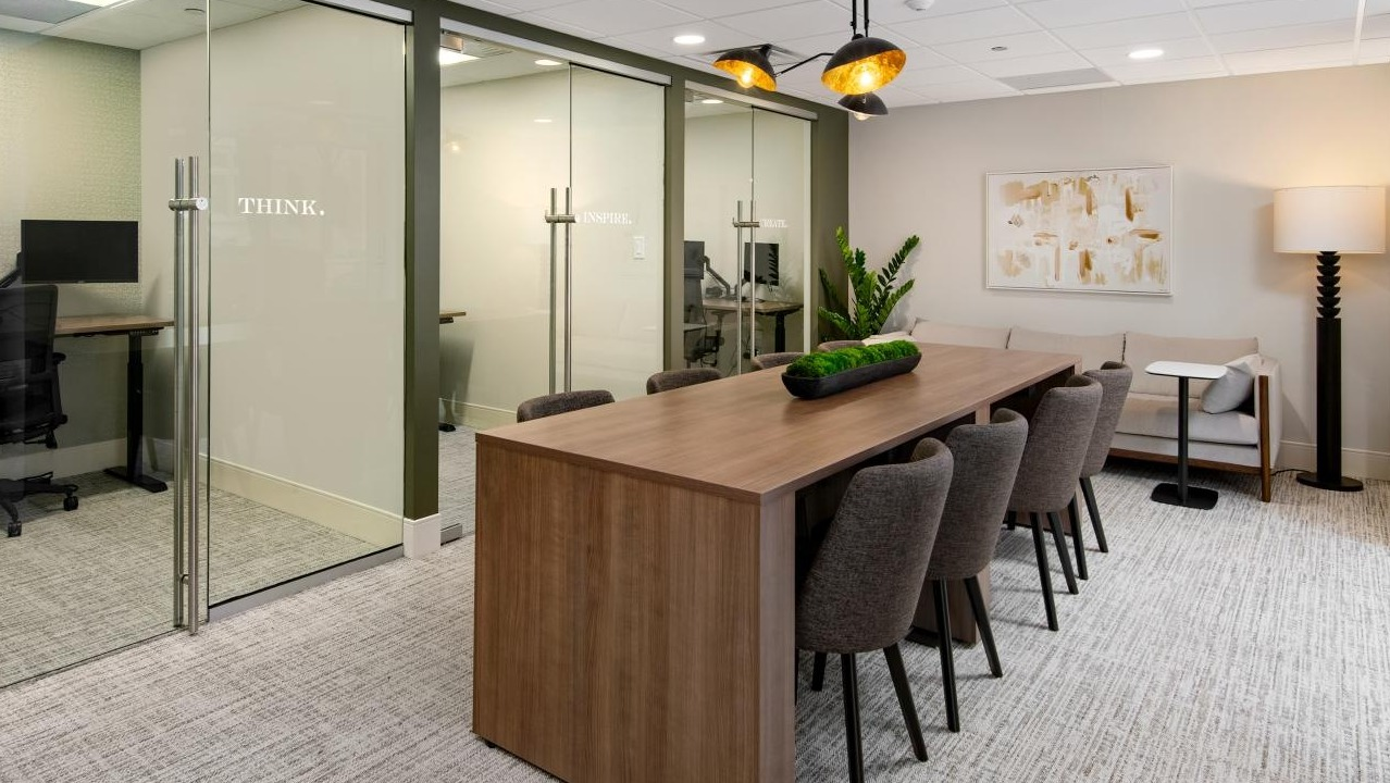 Modern office space at Chestnut Towers with private work pods, a large conference table, and comfortable lounge seating