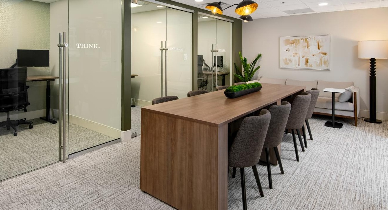 Modern office space at Chestnut Towers with private work pods, a large conference table, and comfortable lounge seating