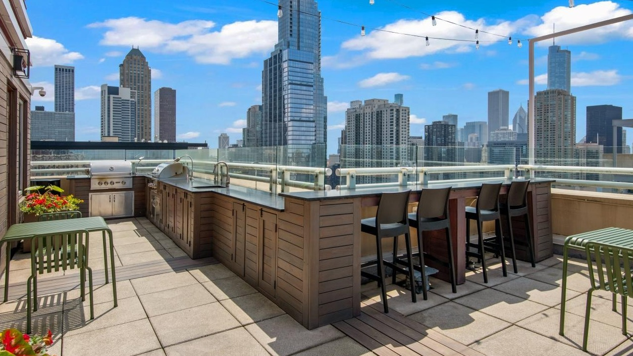 The impressive rooftop deck at Chestnut Towers, including a grilling station, bar seating, and stunning city views
