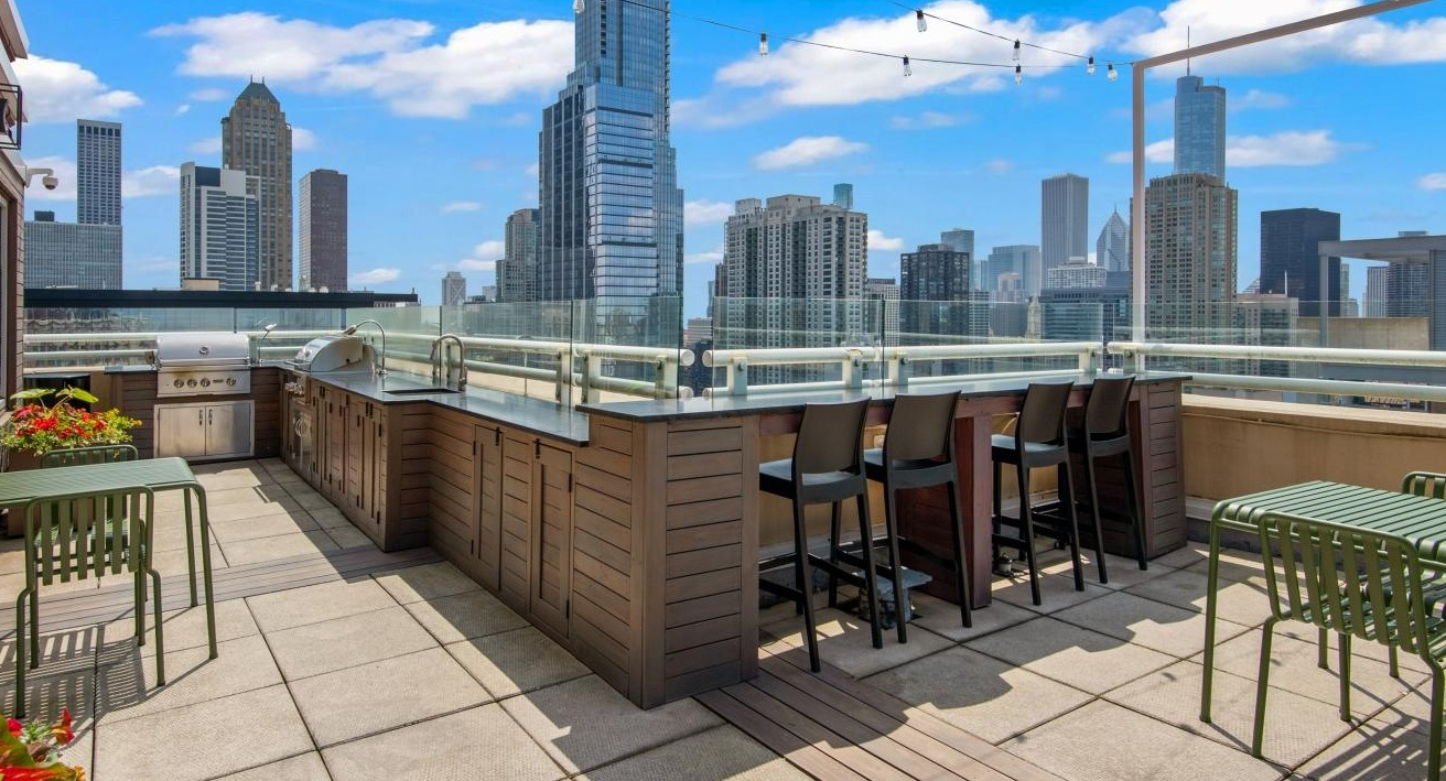 The impressive rooftop deck at Chestnut Towers, including a grilling station, bar seating, and stunning city views