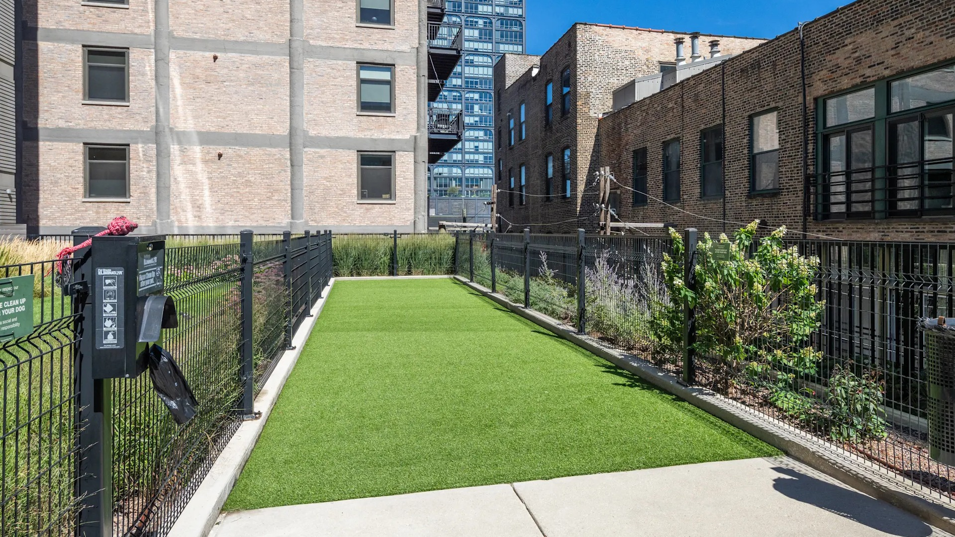 Outdoor pet relief area with artificial turf, surrounded by fencing, catering to pet owners at Circa 922 in Chicago