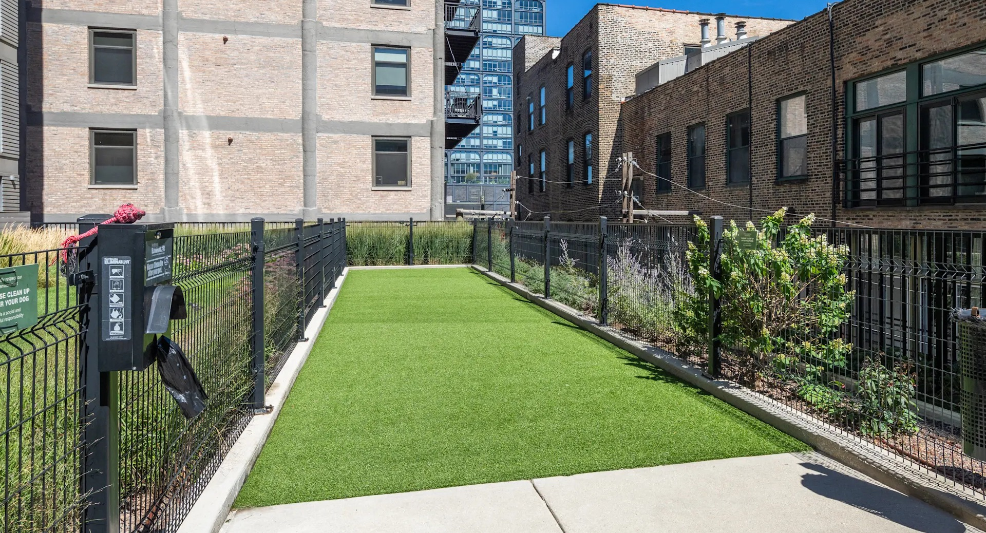 Outdoor pet relief area with artificial turf, surrounded by fencing, catering to pet owners at Circa 922 in Chicago