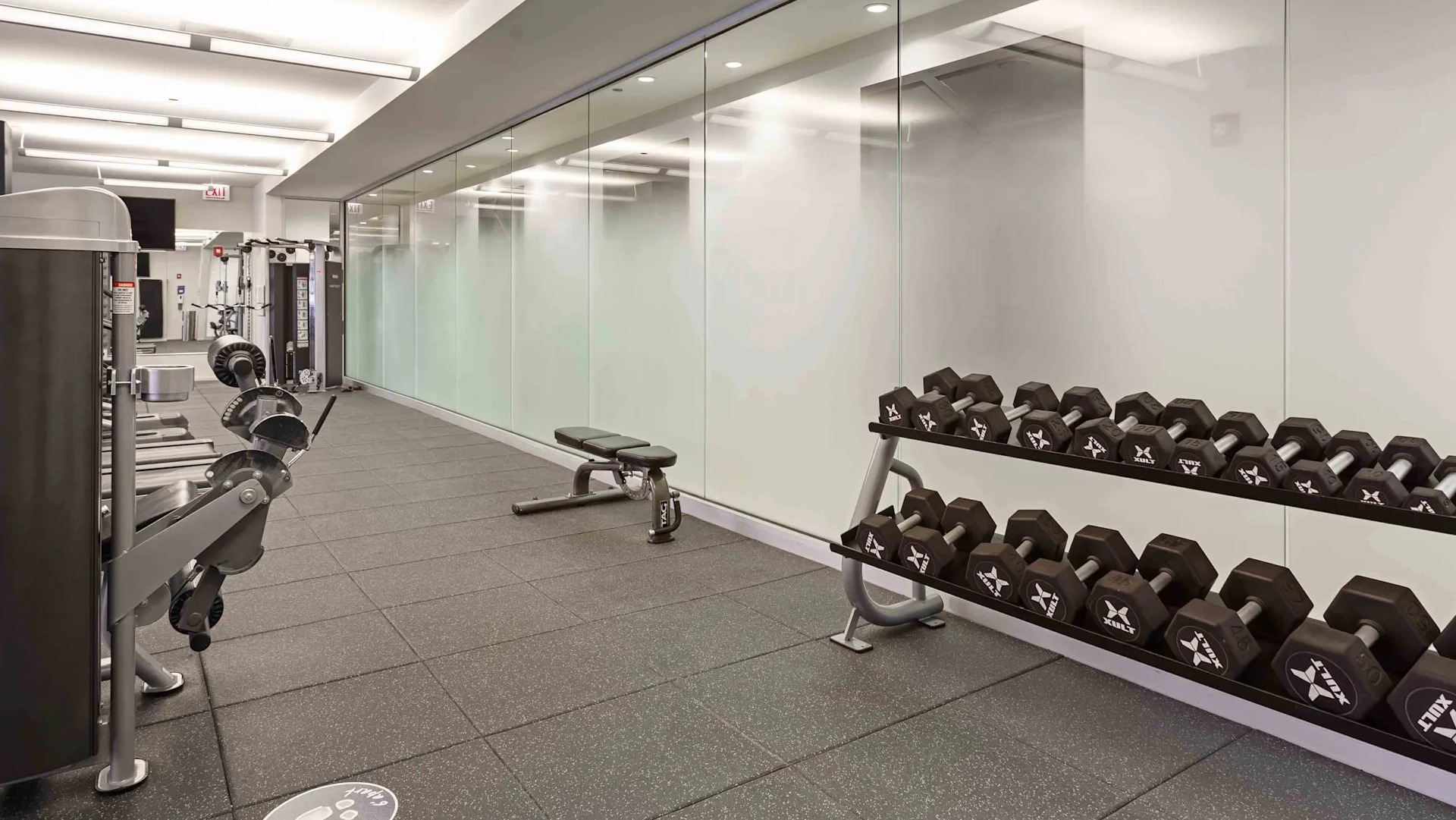Well-equipped fitness center with various exercise machines and a rack of dumbbells at Circa 922 apartments in Chicago