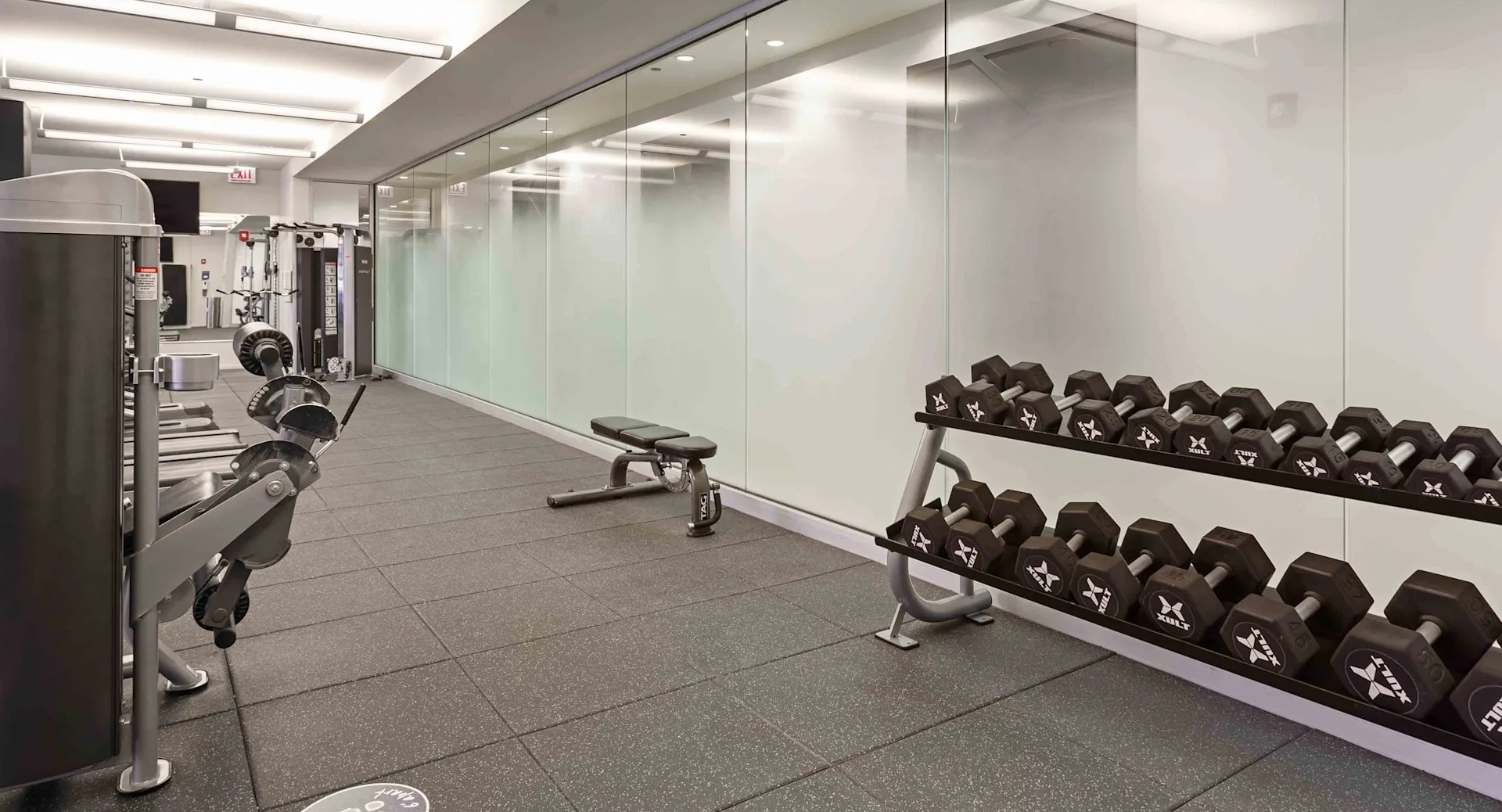 Well-equipped fitness center with various exercise machines and a rack of dumbbells at Circa 922 apartments in Chicago