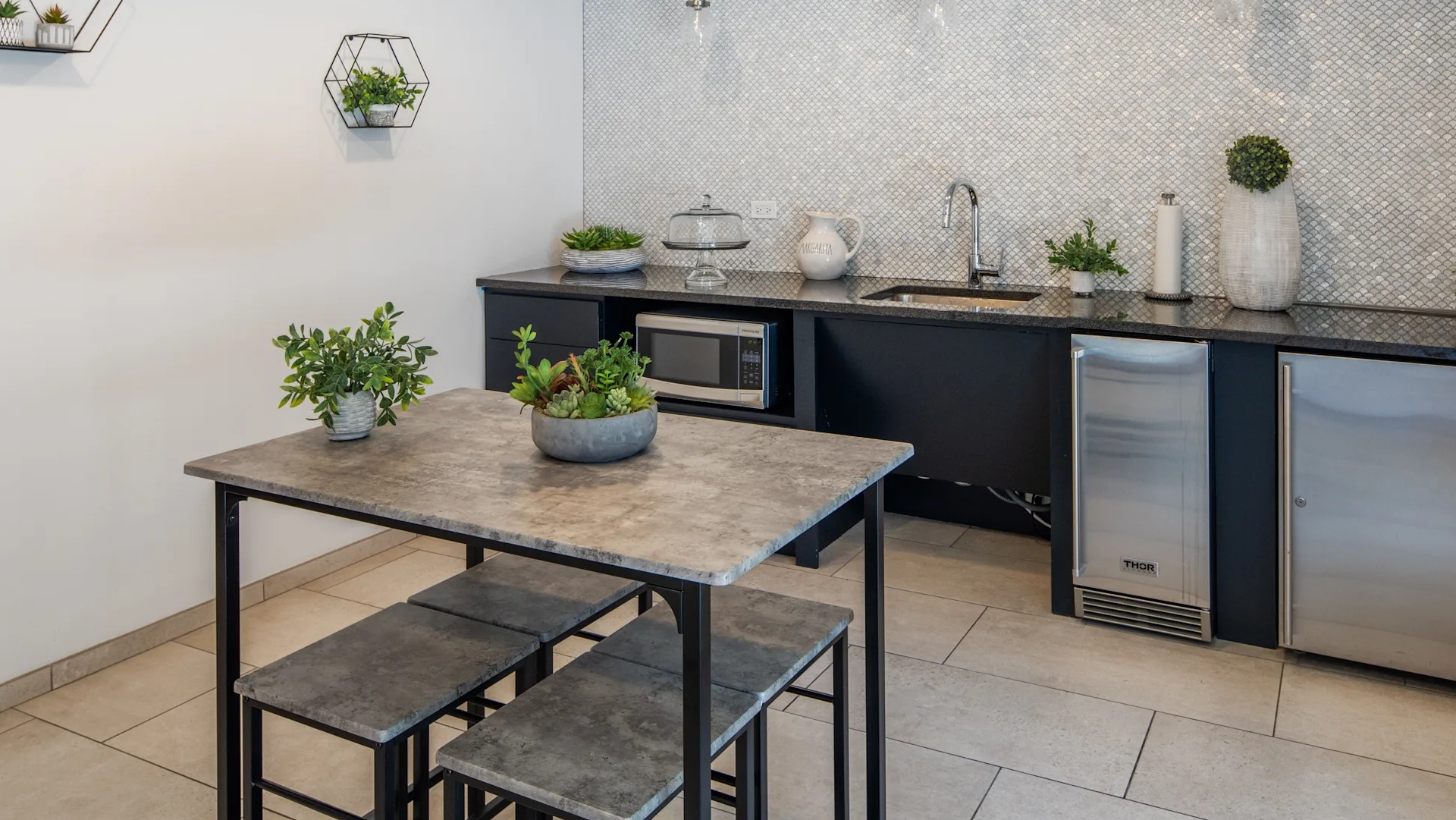 Modern kitchenette with a built-in microwave, sink, and mini-fridge, featuring a sleek design in Circa 922 in Chicago