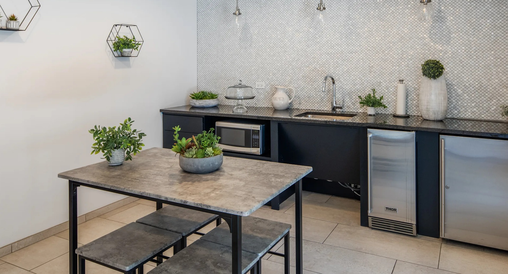 Modern kitchenette with a built-in microwave, sink, and mini-fridge, featuring a sleek design in Circa 922 in Chicago
