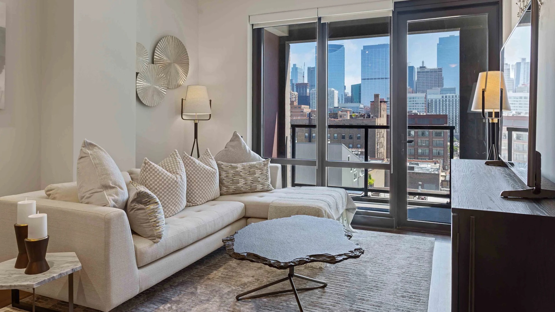Cozy living room with a large sectional sofa, modern decor, and expansive city views at Circa 922 apartments in Chicago
