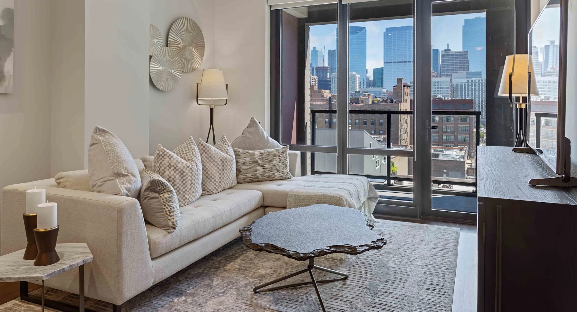 Cozy living room with a large sectional sofa, modern decor, and expansive city views at Circa 922 apartments in Chicago