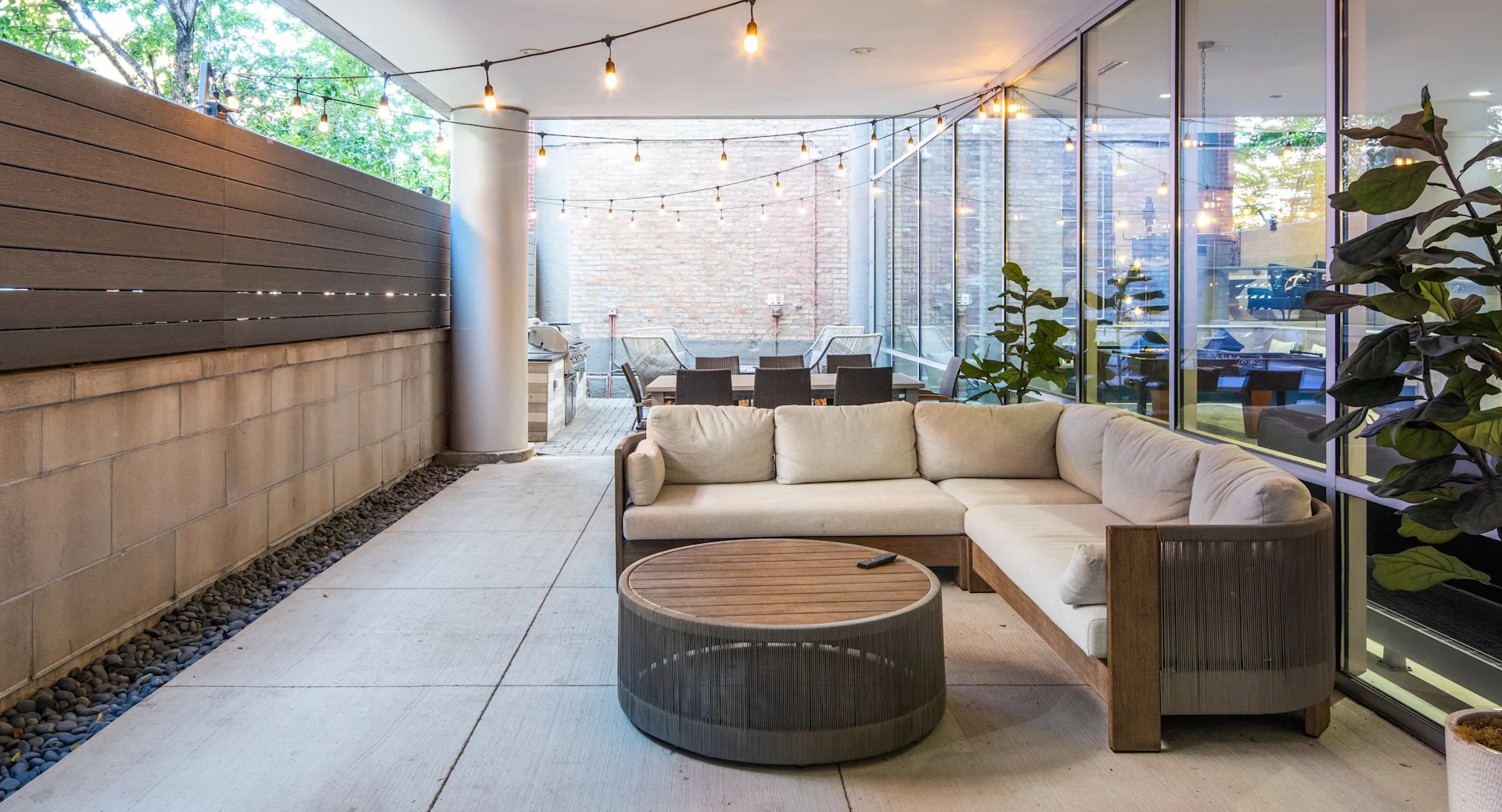 Covered outdoor lounge patio with comfortable sectional seating, string lights, and a large screen for entertainment at Circa 922 in Chicago
