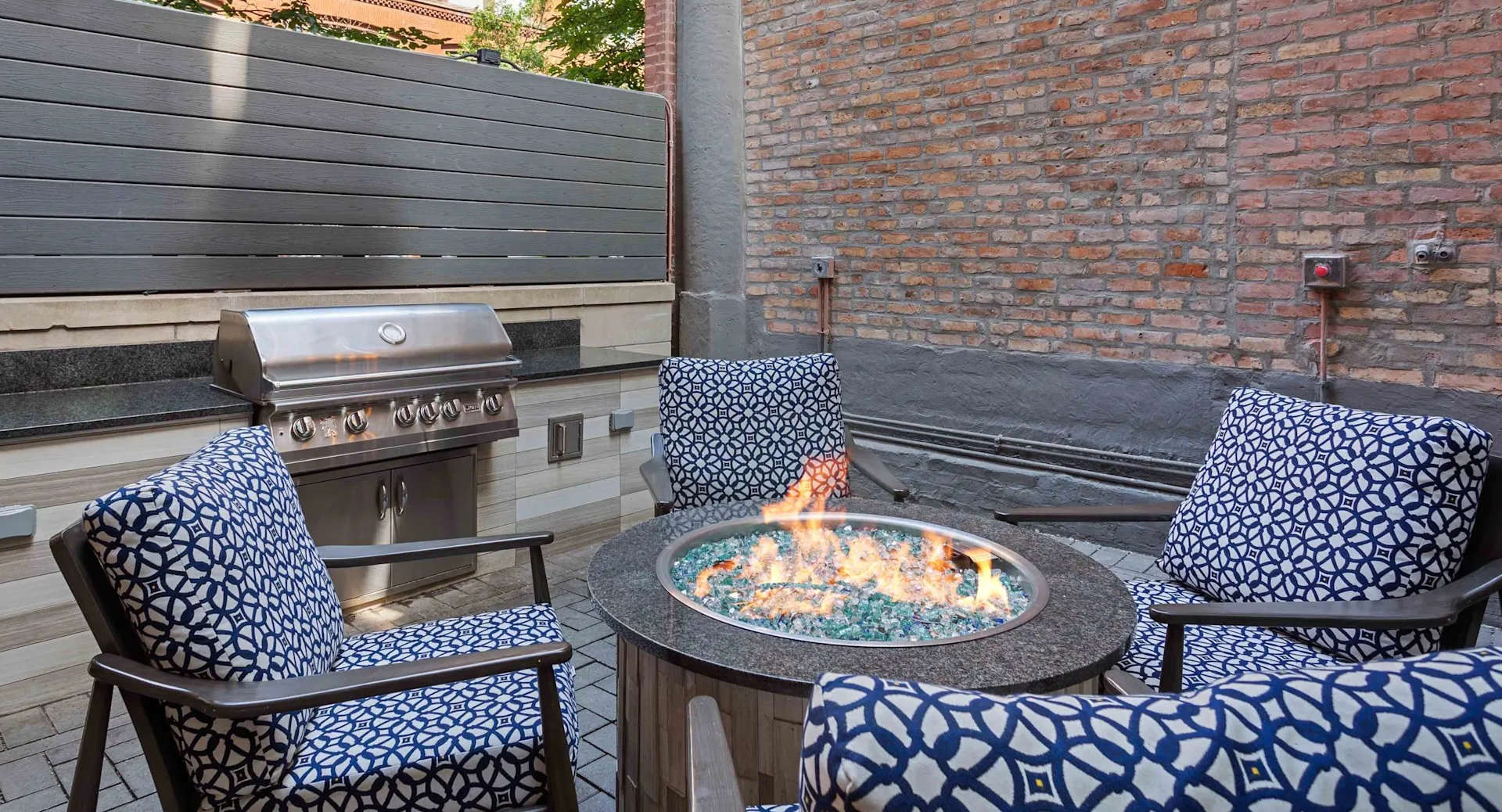 Inviting outdoor patio with a fire pit, comfortable seating, and a grill station at Circa 922 apartments in Chicago