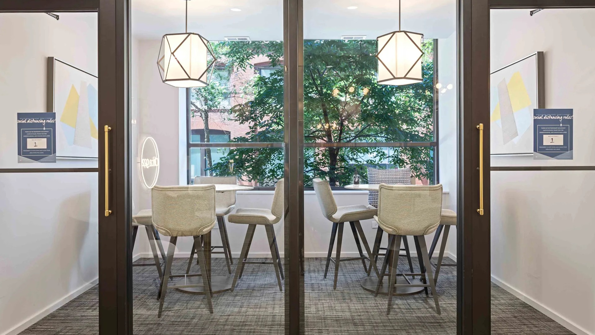 Two modern, glass-enclosed private work nooks with tables and chairs, perfect for focused work at Circa 922 in Chicago
