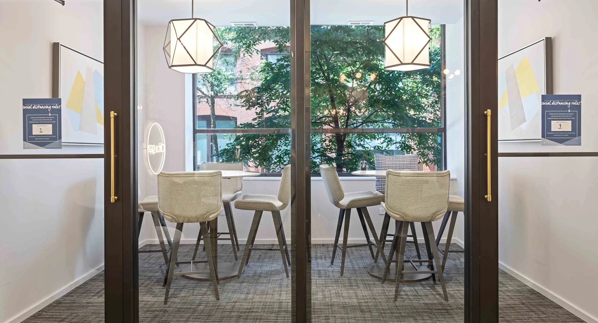 Two modern, glass-enclosed private work nooks with tables and chairs, perfect for focused work at Circa 922 in Chicago