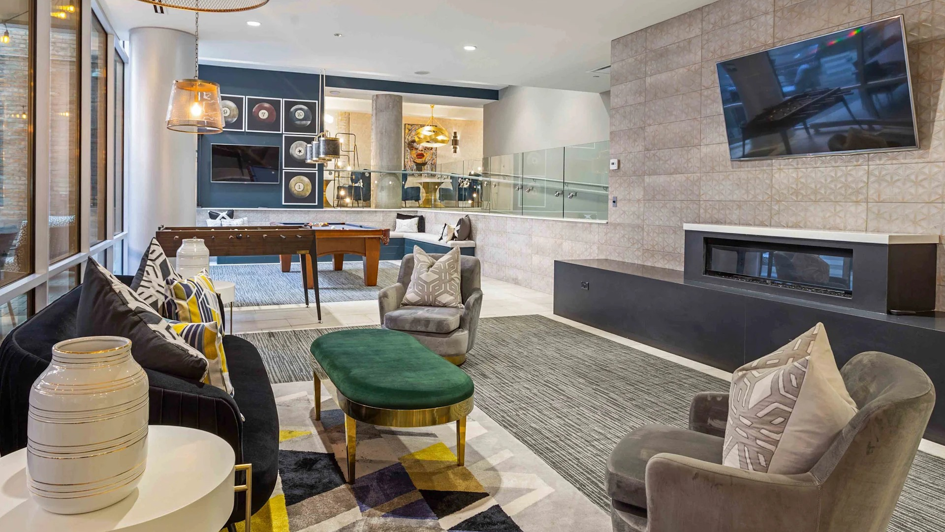 Spacious resident lounge with diverse seating, a fireplace, and a view into the game room at Circa 922 apartments in Chicago