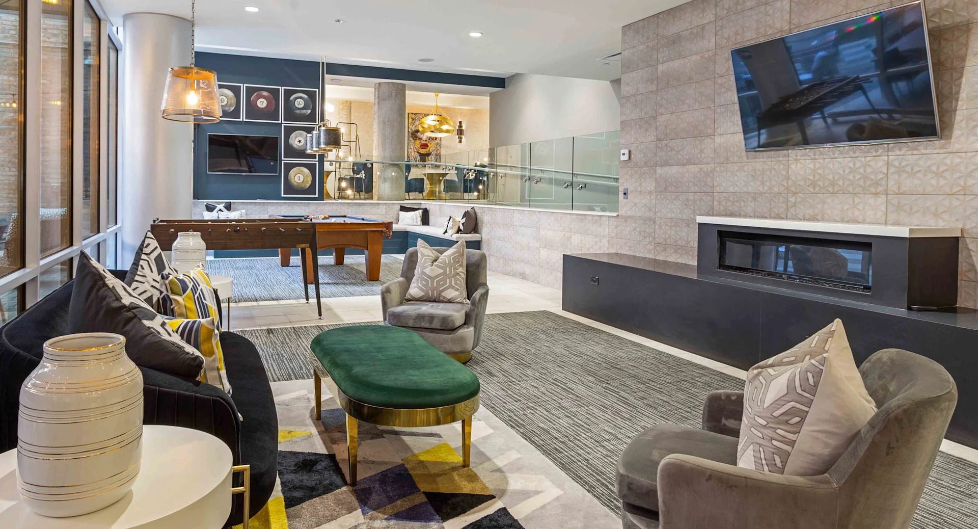 Spacious resident lounge with diverse seating, a fireplace, and a view into the game room at Circa 922 apartments in Chicago