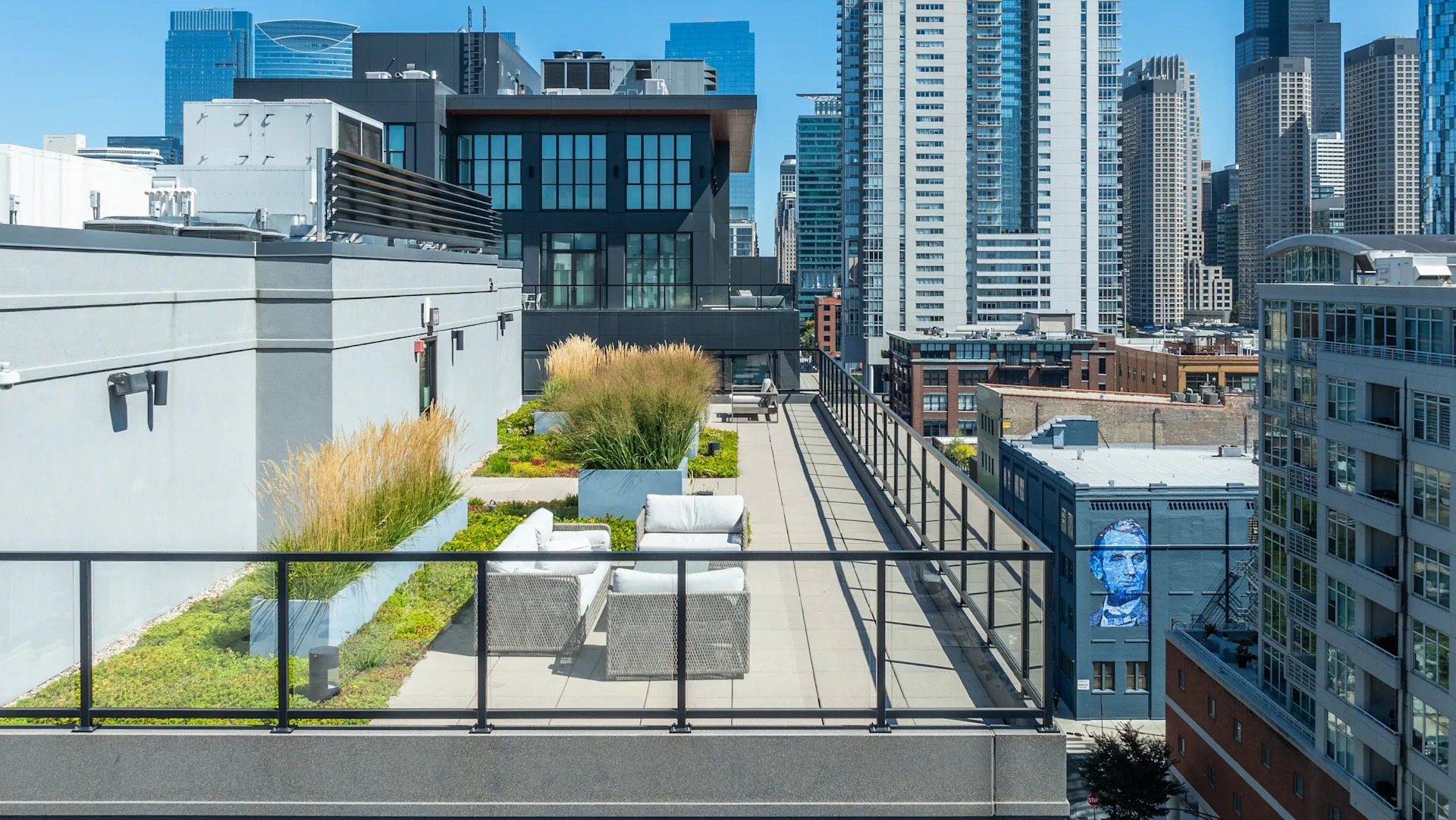 Expansive rooftop deck with comfortable seating areas, lush greenery, and stunning views of the Chicago skyline at Circa 922
