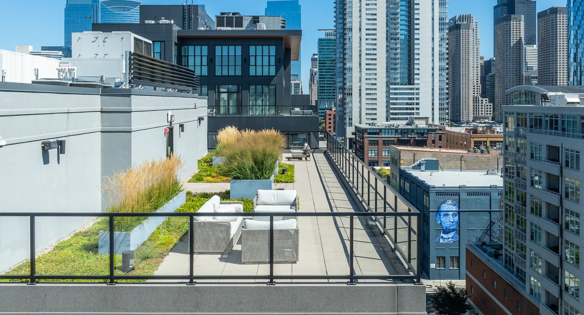 Expansive rooftop deck with comfortable seating areas, lush greenery, and stunning views of the Chicago skyline at Circa 922