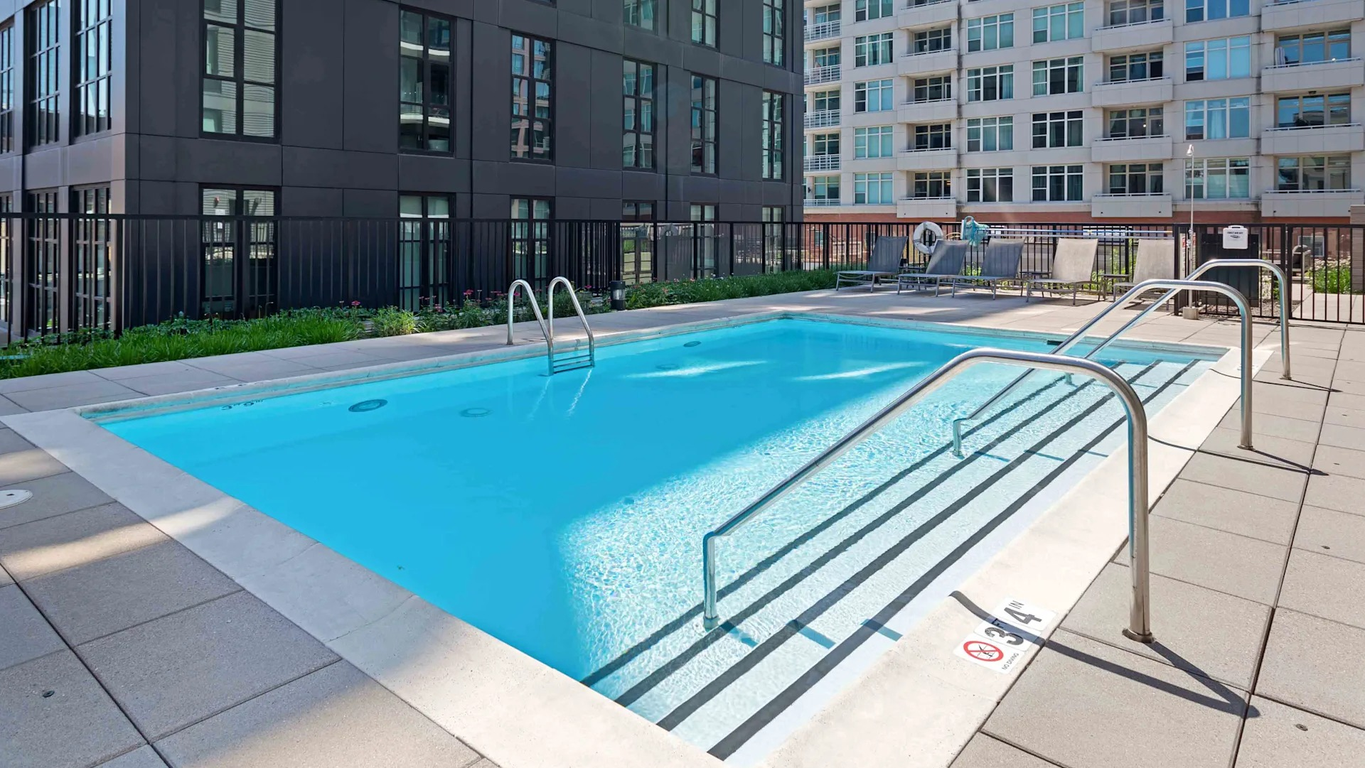 Serene rooftop swimming pool offering stunning city views, surrounded by lounge chairs at Circa 922 apartments in Chicago