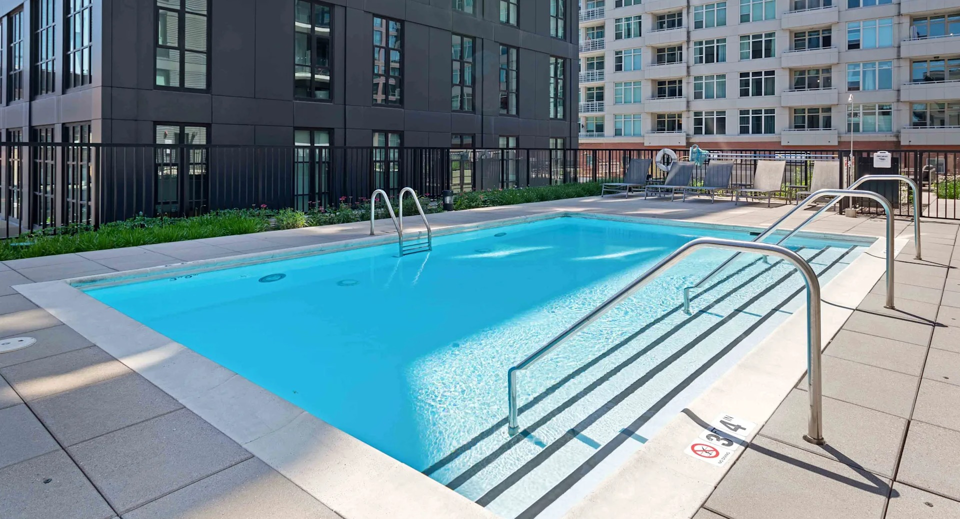 Serene rooftop swimming pool offering stunning city views, surrounded by lounge chairs at Circa 922 apartments in Chicago