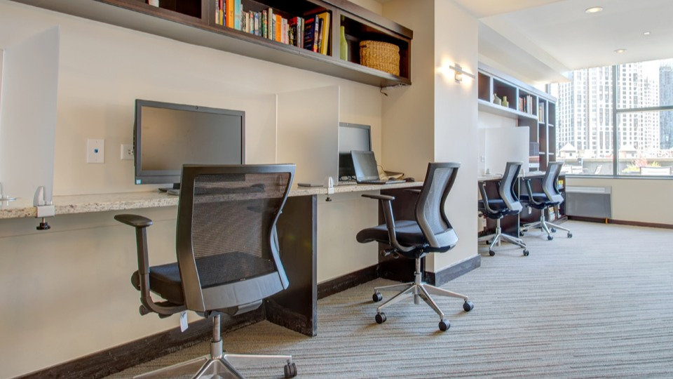 Modern business center at Cityfront Place with multiple workstations, comfortable chairs, and city views