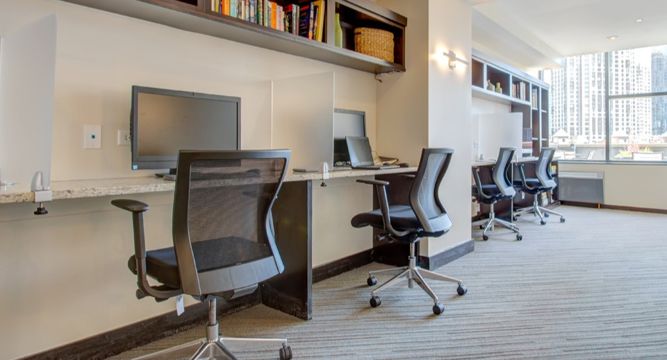 Modern business center at Cityfront Place with multiple workstations, comfortable chairs, and city views