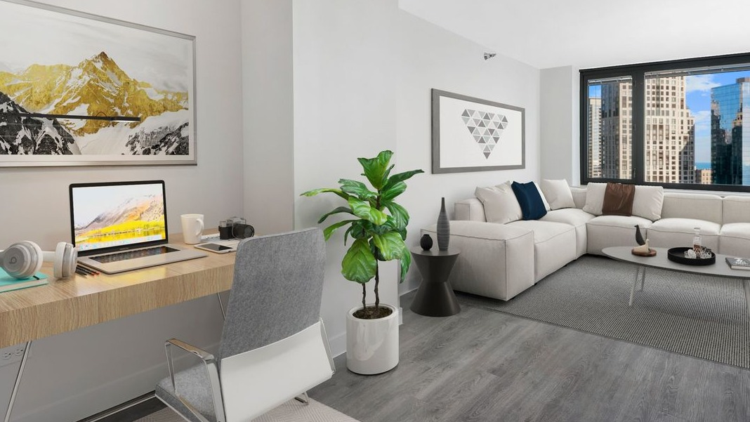 Inviting living area with a comfortable couch and a dedicated workspace, featuring city views at Cityfront Place